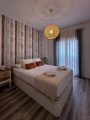 a bedroom with a large bed and a chandelier at Dos Mundos in Motril