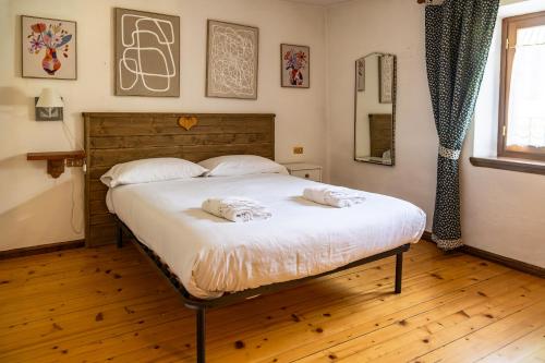 ein Schlafzimmer mit einem Bett mit zwei Handtüchern darauf in der Unterkunft Chalet Carillo - 4 camere in pieno centro di Fiera di Primiero in Fiera di Primiero