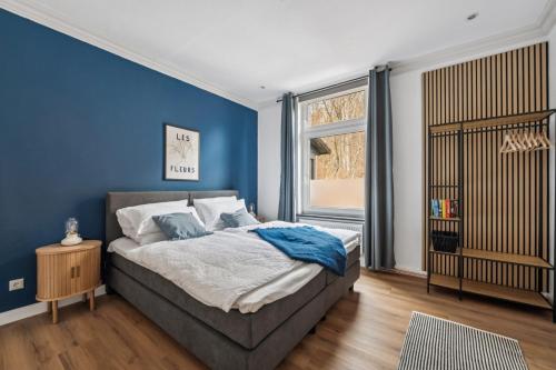 Un dormitorio azul con una cama y una ventana. en NEU! Gruppenurlaub mit Sauna im Plöner Seengebiet, en Malente