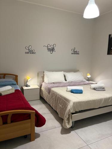 a bedroom with two beds and two lamps at Apartament house in Marcianise