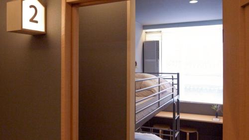 a room with a bunk bed and a window at Little Birds Hostel in Omihachiman