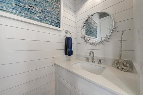 een badkamer met een wastafel en een spiegel bij Port Aransas Sunset in Mustang Beach