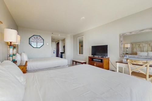 Bayside at Sandestin 6681 في ديستين: غرفة نوم بيضاء بسريرين وتلفزيون