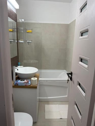 a bathroom with a tub and a sink and a toilet at Urban apartament in Craiova