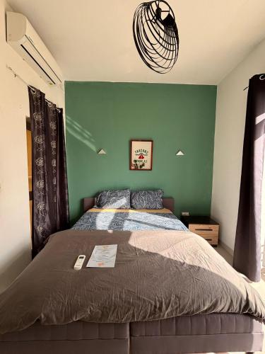a bedroom with a bed with a green wall at Next to beach Sliema Stay, Cozy, Air-Conditioned, Self Check-In in Il-Gżira