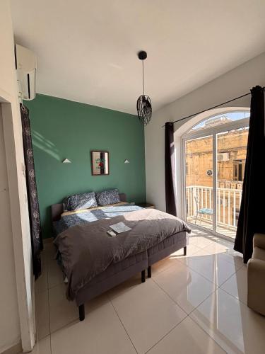 a bedroom with a bed and a green wall at Next to beach Sliema Stay, Cozy, Air-Conditioned, Self Check-In in Il-Gżira