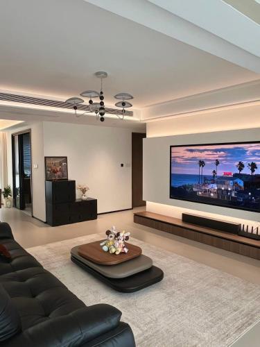 a living room with a couch and a large screen tv at Warren appart in Lomé