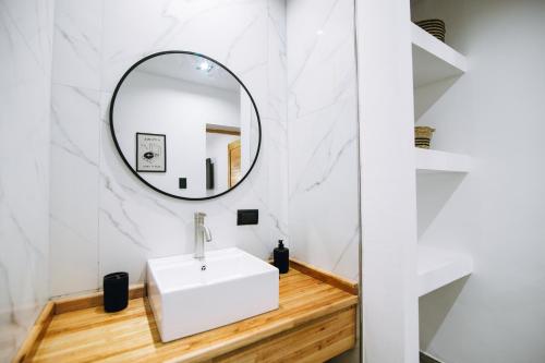 een badkamer met een witte wastafel en een spiegel bij Complejo Malama Kai in Mar de Cobo