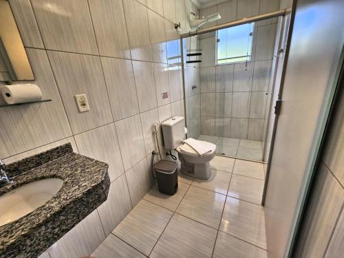 une salle de bains avec douche, toilettes et lavabo dans l'établissement Pousada Refúgio Serrano, à Serra Negra