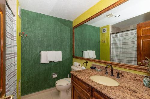 een badkamer met een wastafel, een toilet en een spiegel bij Sonoran Spa W409 in Campo del Medio