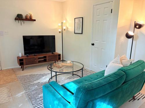 ein Wohnzimmer mit einer grünen Couch und einem Tisch in der Unterkunft Cozy Apartment a few steps from The Capitol in Salt Lake City