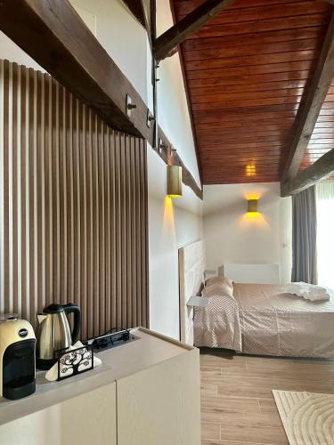 a bedroom with a bed and a kitchen with a microwave at Il Casale della Baronessa in Palmi
