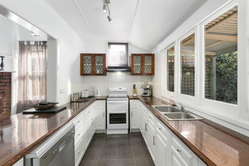 a kitchen with white counters and white appliances at Magnolia Cottage in Healesville