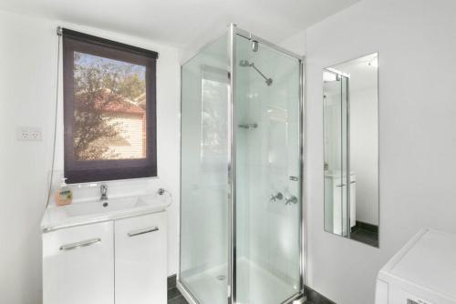 ein weißes Badezimmer mit Dusche und Waschbecken in der Unterkunft Magnolia Cottage in Healesville