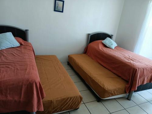 two beds sitting next to each other in a room at Twin Towers Tres Mares in Acapulco