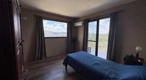 une chambre avec un lit et deux grandes fenêtres dans l'établissement Vivaldi 192 Villa Carlos Paz, Córdoba, à Villa del Lago
