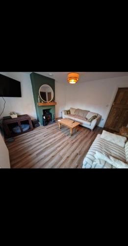 The Cosy House في ويلينغتون: غرفة معيشة بها سريرين وأريكة