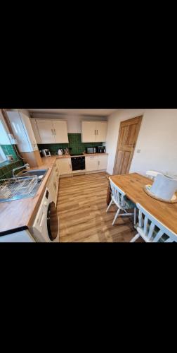 The Cosy House في ويلينغتون: مطبخ كبير مع طاولة وموقد