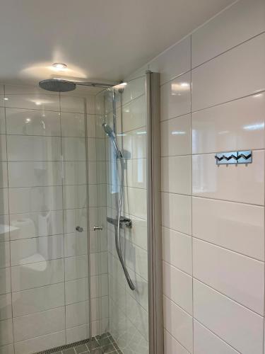 a shower with a glass door in a bathroom at Röda Stugan in Örby, Älvsjö in Stockholm