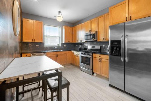 a kitchen with wooden cabinets and a stainless steel refrigerator at Kenwood Apartments, Downtown Hyde Park in Chicago