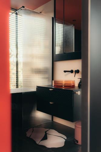 a bathroom with a glass shower and a sink at Īves, Koka Maja in Amatciems