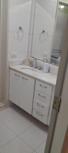 a white bathroom with a sink and a mirror at Angel's House Flamengo RJ in Rio de Janeiro