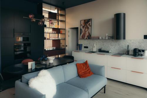 a living room with a couch and a kitchen at Īves, Koka Maja in Amatciems