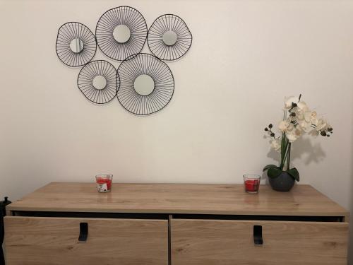 a wooden cabinet with a vase of flowers on a wall at Résidence Flores De Maria in Le Marin