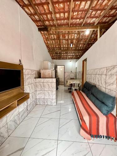 a living room with a couch and a tv in it at Casa em Itacaré no Centro, ao lado da Pituba in Itacaré