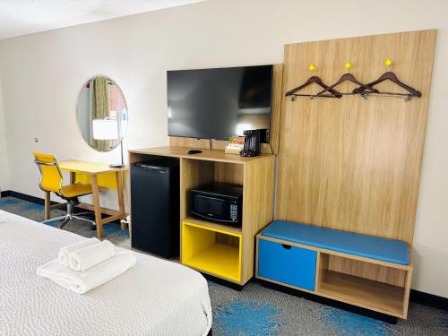 ein Hotelzimmer mit einem Bett und einem Fernseher in der Unterkunft HomeLodge Newnan in Newnan