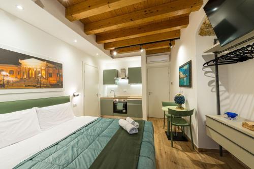 a hotel room with a bed and a kitchen at Caminneci Palace Boutique in Palermo