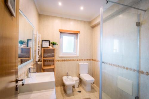 ein Badezimmer mit Toilette, Waschbecken und Dusche in der Unterkunft Surf Lodge Santa Cruz in Silveira