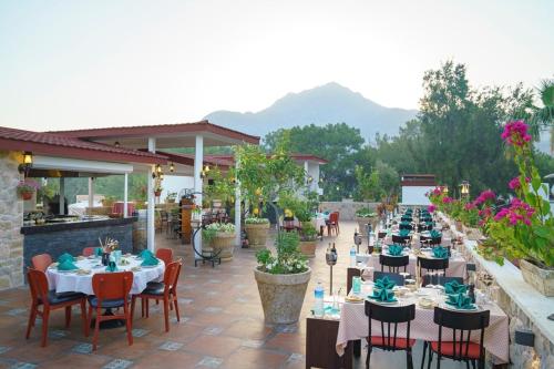 a patio with long tables and chairs and flowers at Pirates Beach Club -Ultra All Inclusive in Tekirova