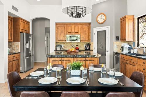 eine Küche mit einem schwarzen Tisch und Stühlen sowie eine Küche mit Holzschränken in der Unterkunft Featured on StayCation-Heated Pool-Golf Course-Hot tub in New River