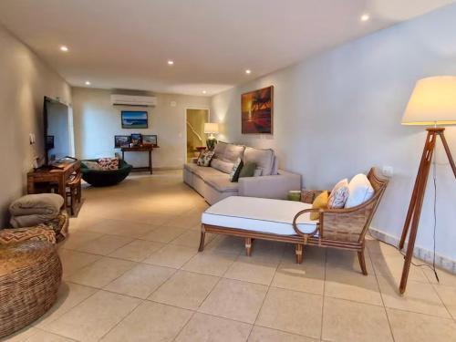 a living room with a couch and a table at NOVO Mansão Pé na Areia com Heliponto, 1 Piscina, 1 Hidro, Sauna e 5 Quartos in Angra dos Reis