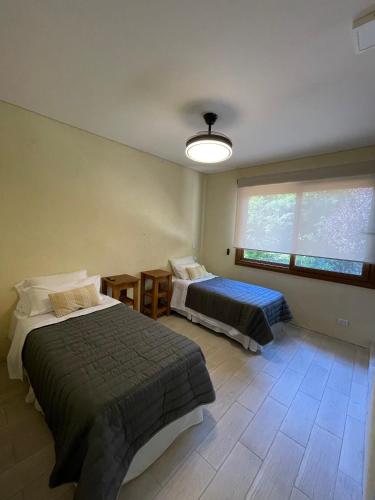 a bedroom with two beds and a large window at La Madriguera de Potrerillo in Alta Gracia