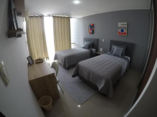 ein kleines Schlafzimmer mit zwei Betten und einem Fenster in der Unterkunft Serenity Palmas- in Santa Cruz de la Sierra