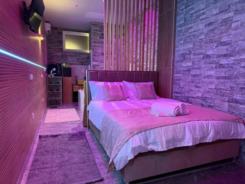a bedroom with a large bed with pink sheets at Dubai Spa Apartment #1 - Jacuzzi & Sauna Free Parking in Novi Sad