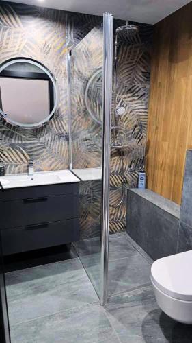 a bathroom with a sink and a mirror on a wall at RG Apartments in Šamorín