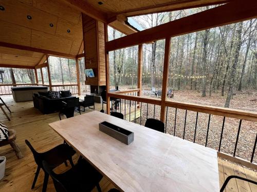 une grande chambre avec une table et des chaises dans une cabine dans l'établissement The Stunning Shady Creek Cabin, à Broken Bow