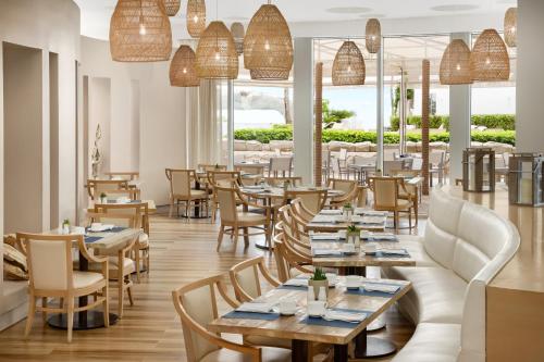 a restaurant with tables and chairs and windows at Trump International Beach Resort - Sunny Isles Beach in Miami Beach