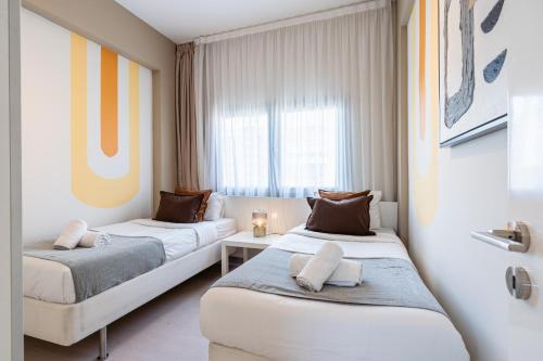 a hotel room with two beds and a window at Local Host Living - Signature Apartments in Nicosia in Nicosia