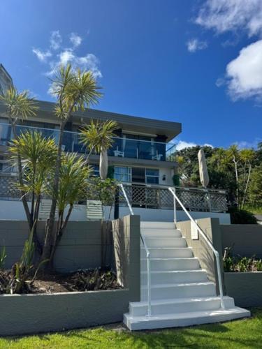 uma escada que leva a uma casa com palmeiras em San Marino Motor Lodge em Coopers Beach