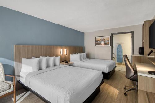 a hotel room with two beds and a desk at Best Western Of Walterboro in Walterboro