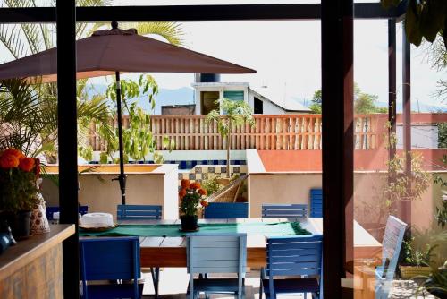 un patio avec une table, des chaises et un parasol dans l'établissement El Diablo y La Luna B&B by El Diablo y La Sandia, à Oaxaca
