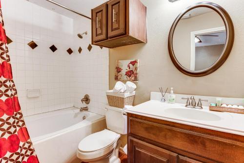 Un baño con lavabo, inodoro y espejo. en Explore Houston and Beyond! Spring Home with Backyard, en Klein