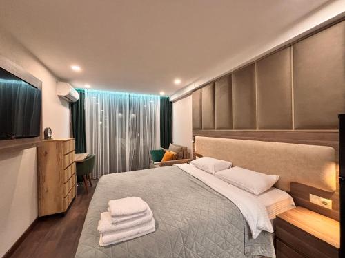Un dormitorio con una cama grande con toallas. en Apartments 1 line sea WYN RESIDENS, en Batumi