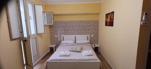 a small bedroom with a bed with towels on it at la primavera in Palmi