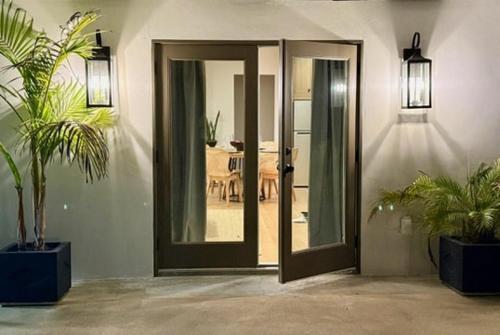 a room with two potted plants in front of a door at Hillside Haven | Boutique Spanish Escape in Ojai