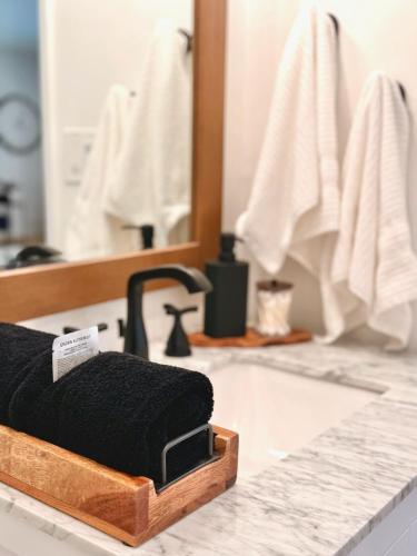 a black towel sitting on a bathroom counter in front of a mirror at Hillside Haven | Boutique Spanish Escape in Ojai